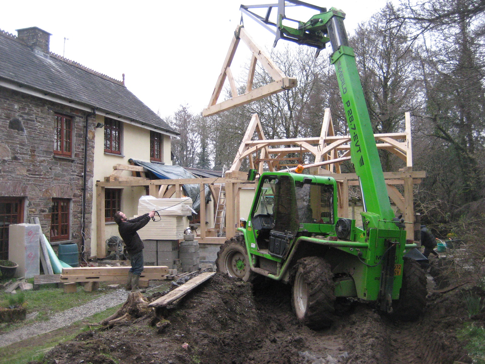 Queen post truss green oak timber frame being installed in Devon