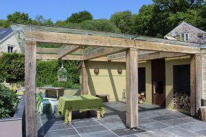 Green Oak timber framed glass roof pergola gazebo at Everafter wedding venue tavistock chunky frame glazed roof barbecue shelter with corten fireplace and chimney