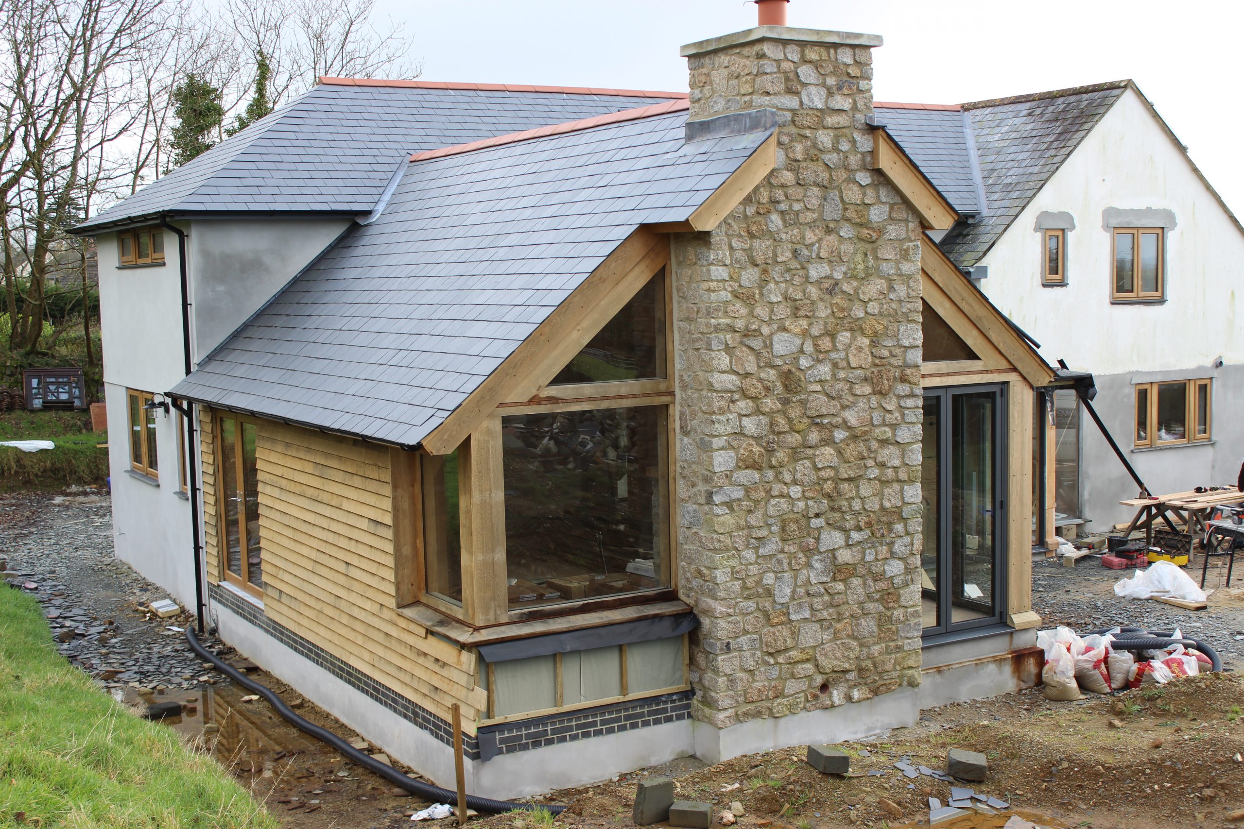 traditional green oak timber framed house extension with sweet chestnut cladding in devon