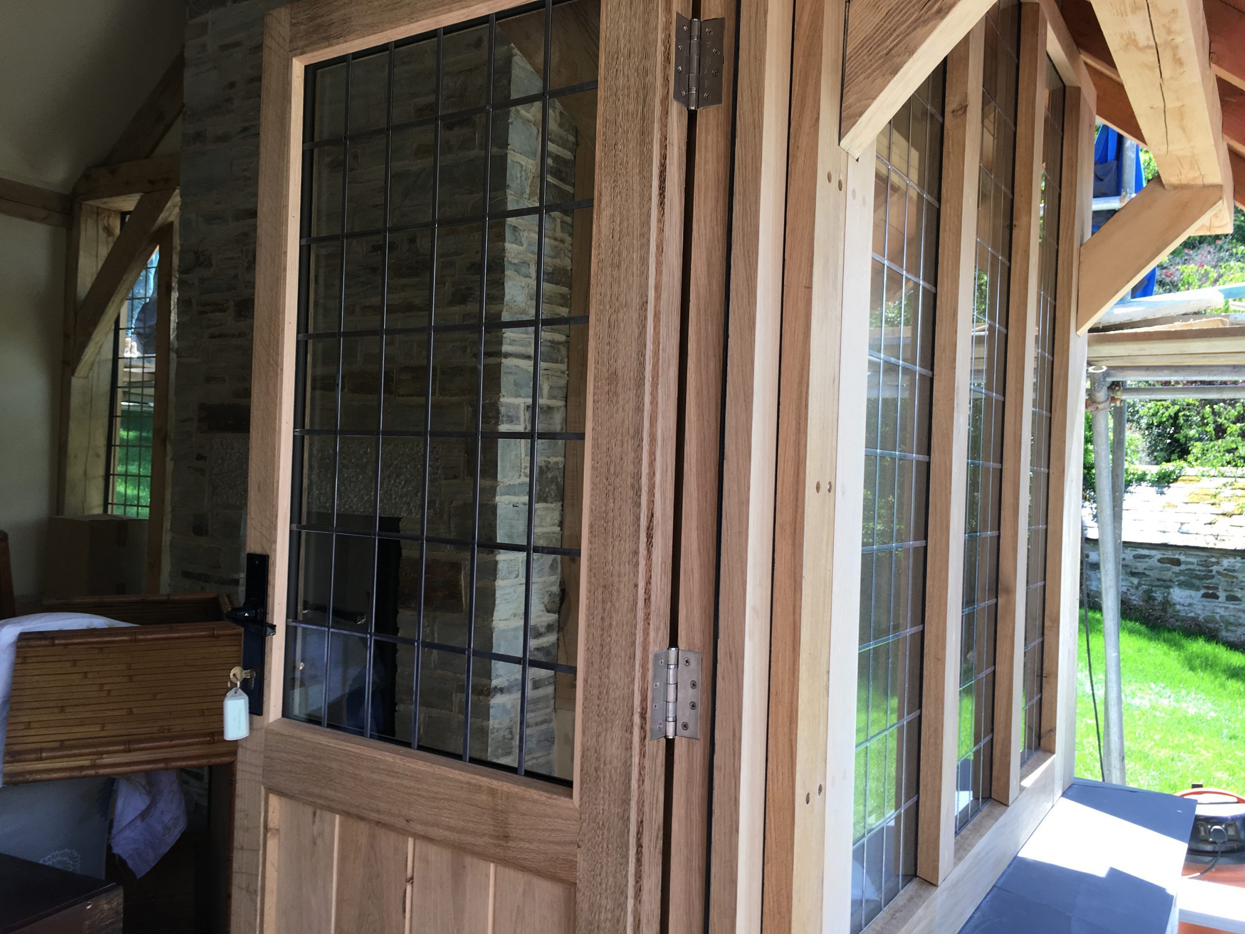 hand made bespoke oak french doors and georgian leaded glass double glazing on a green oak timber frame