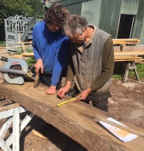 student on traditional post and beam heritage skills training course receiving on the job timber frame instruction