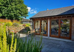 sunny terrace with green oak timber framed cabin in devon countryside
