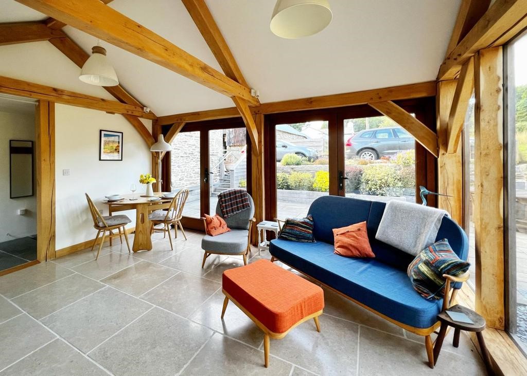 a comfy sofa in a timber framed cabin with character trusses and curved braces